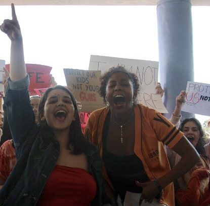Senior Cecilia Campillo stands on the table and brings the protestors together as they shout chants on gun control. (photo courtesy of Brianne Guanaga)