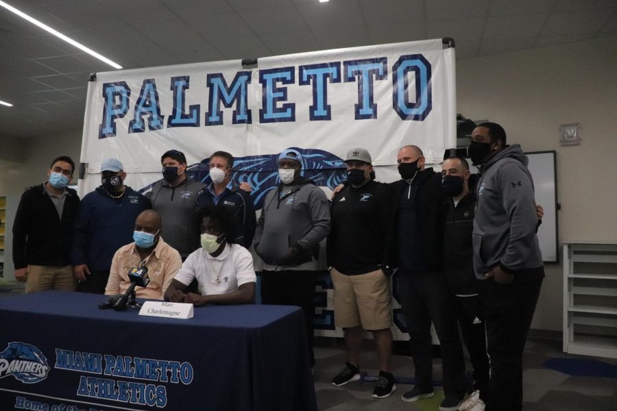 Charlemagne takes a picture with the football coaching staff. 