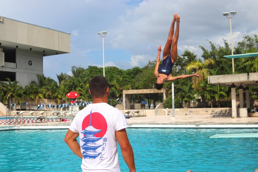 Coach Briadam Herrera critiques Senior and Dive Team Captain Isabella Reyess dive during practice.