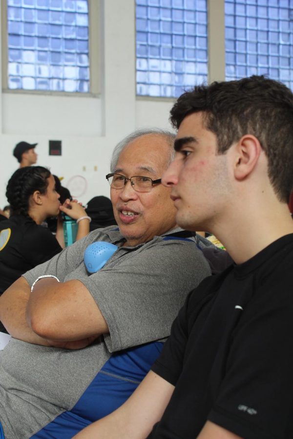Varsity Badminton Coach Dave Zarco gives advice to player Michael Margado (11) in between games at the Youth Fair Tournament.