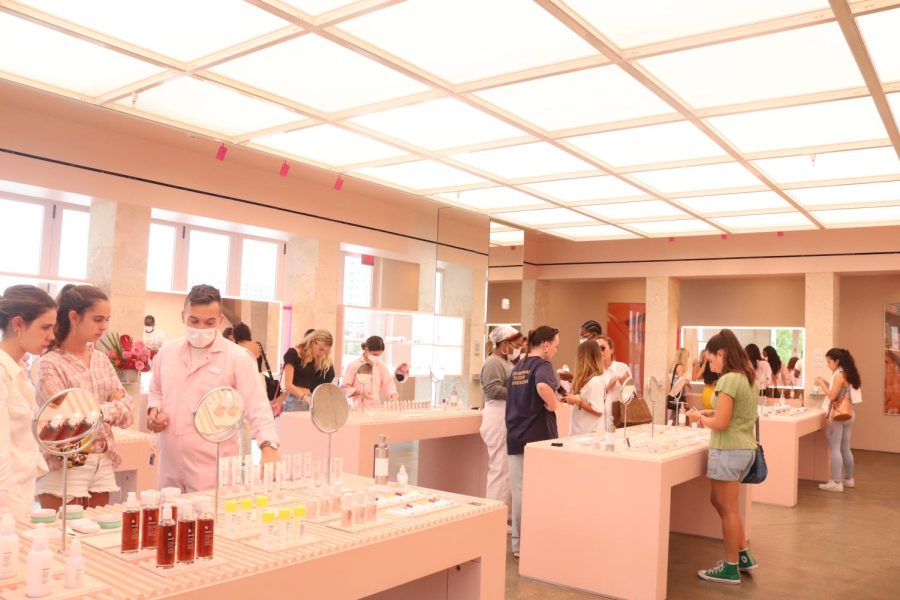 Glossier store filled with new shoppers browsing products.